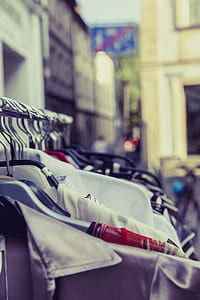 Shallow Focus Photography of Shirts Hang on Silver Clothes Rack Under Sunny Sky thumbnail
