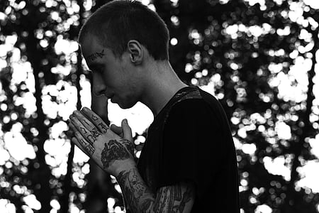 grayscale photography of man using praying sign thumbnail