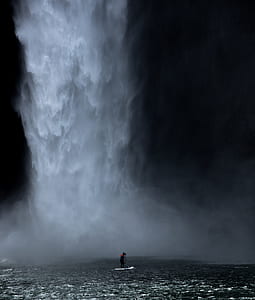 man riding paddleboard on body of body of water thumbnail