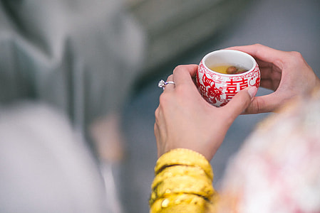 person holding white and red ceramic teacup thumbnail