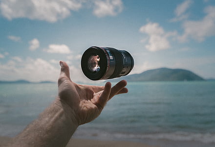 person tossing camera lens thumbnail