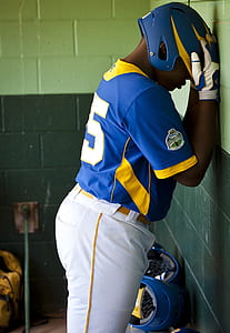 man holding his helmet against the wall thumbnail