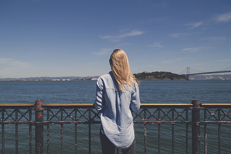 woman standing front of rail guard near sea at daytime thumbnail