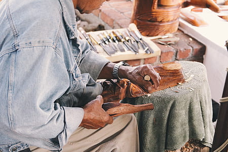 man carving while wearing silver-colored watch at daytime thumbnail