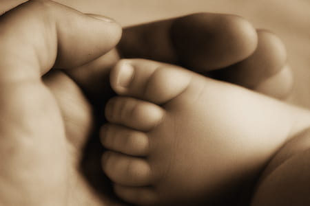 person holding baby foot thumbnail