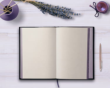 white book with pen on table thumbnail