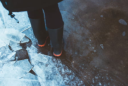 person wearing black rain boots near the ice glass thumbnail