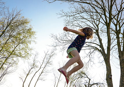 girl jumping near trees thumbnail