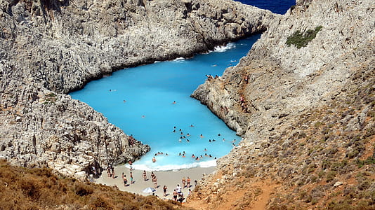 blue ocean surrounded by brown massive rock formation photography during daytime thumbnail