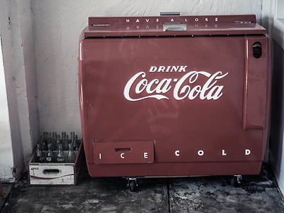 red Coca-Cola vending machine beside white wall thumbnail