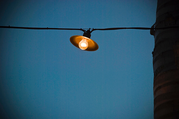portrait of a lamp in a cable wire outside a house