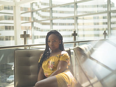 woman sitting on tufted white leather chair inside room thumbnail