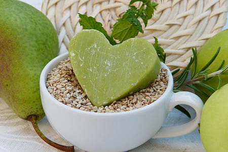 white ceramic cup beside green fruit thumbnail