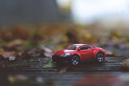 red coupe scale model on floor thumbnail