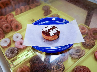 A chocolate donut decorated with vanilla icing lines. thumbnail