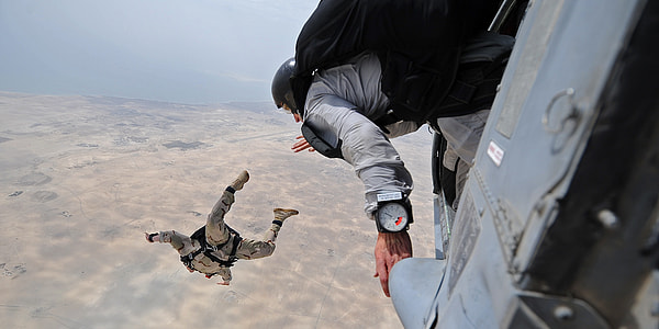 two male sky diving above the ground thumbnail