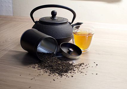 black kettle beside glass cup on top of brown wooden surface thumbnail
