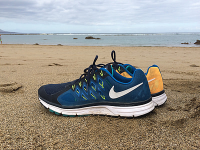 pair of blue Nike shoes on beach shore thumbnail