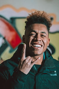man wearing black jacket doing rock and roll hand sign thumbnail
