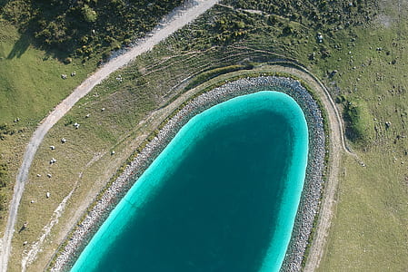 aerial view photo of body of water surrounded by green grass thumbnail