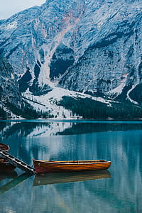 canoe on dock near snow covered mountain thumbnail