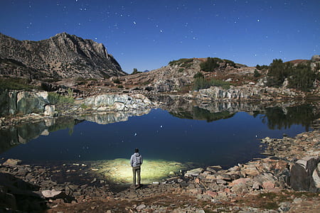 man standing near lake during daytime photo thumbnail