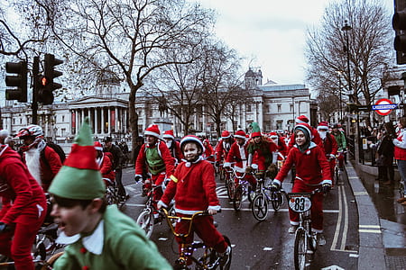 children wearing Santa Clause and Elf costume riding bike during daytime thumbnail