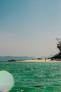 woman standing on seashore near body of water thumbnail