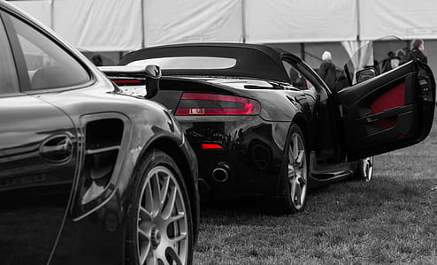 selective color photography of convertible coupe parked on grass field thumbnail