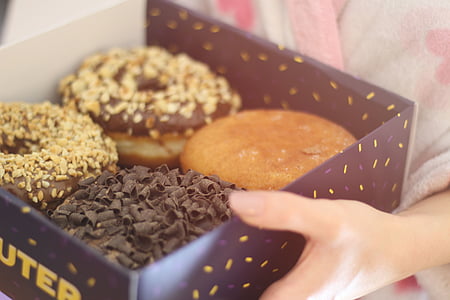 person holding dounut box thumbnail