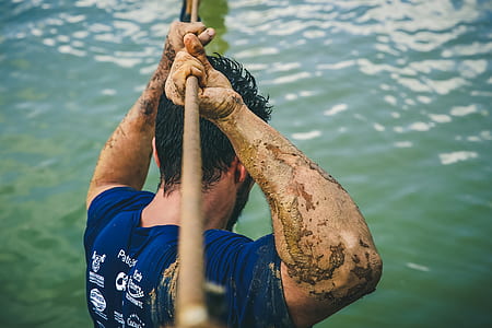 man holding rope near body of water during daytime thumbnail