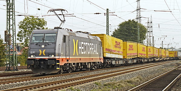 gray and yellow Hectorral train on railway beside transfer tower thumbnail
