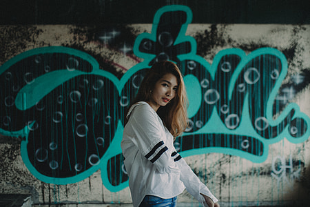 woman standing in front of graffiti painting thumbnail