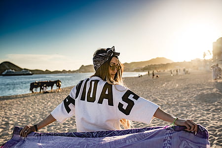 woman sitting white sand at the beach thumbnail