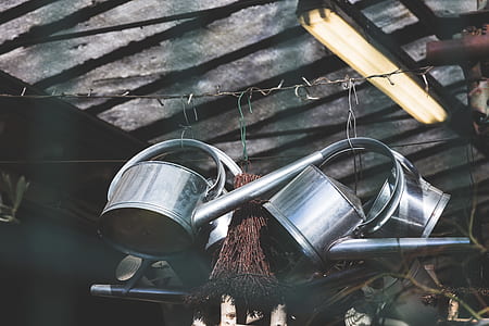 three metal watering can hanged on roof thumbnail
