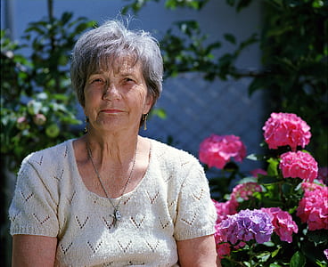 woman wearing white knitted blouse near pink flowers thumbnail