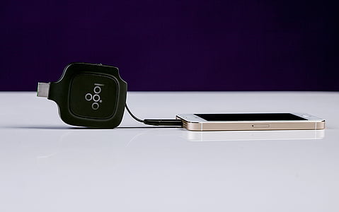 gold iPhone 5s and black connector on white surface thumbnail