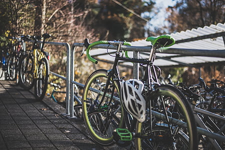 black and green road bike parked beside gray metal railing thumbnail