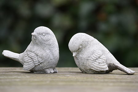 selective focus photography of two grey concrete bird figurines thumbnail