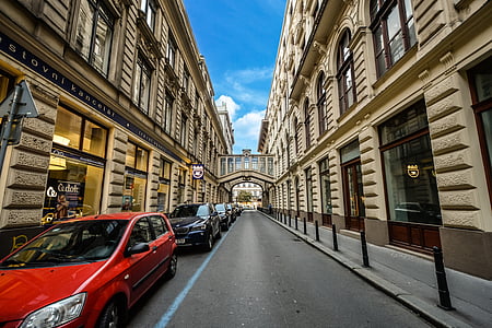 red car between building during daytime thumbnail