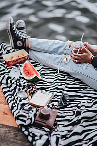 Blonde woman having a healthy snack at the wooden pier thumbnail