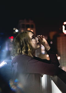 woman standing beside railing looking on stars thumbnail