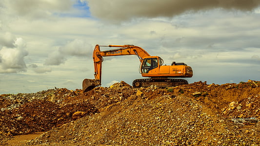 orange and black payloader under cloudy sky thumbnail