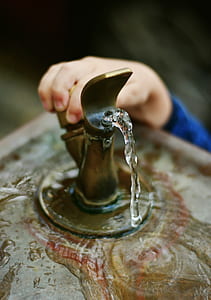 person holding brass-colored spigot thumbnail