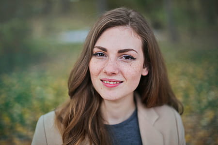 Brown Haired Young Woman In Camel Jacket Looking At Camera thumbnail