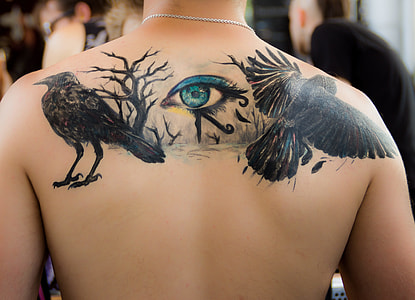 human upper back bird and eye tattoo thumbnail