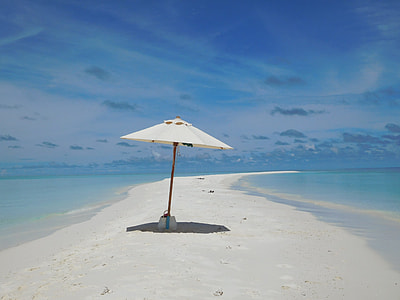 white and brown folding umbrella on beach thumbnail