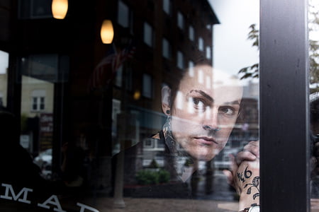 man looking outside through glass wall during daytime thumbnail