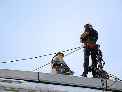 low angle photo of two men on top of gray concrete structure thumbnail