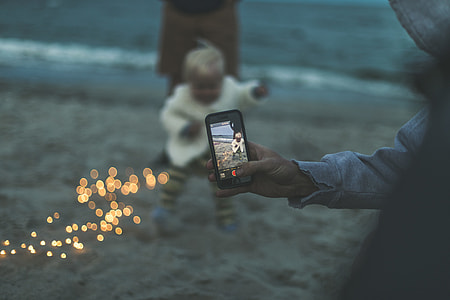 bokeh photography of person capturing baby thumbnail